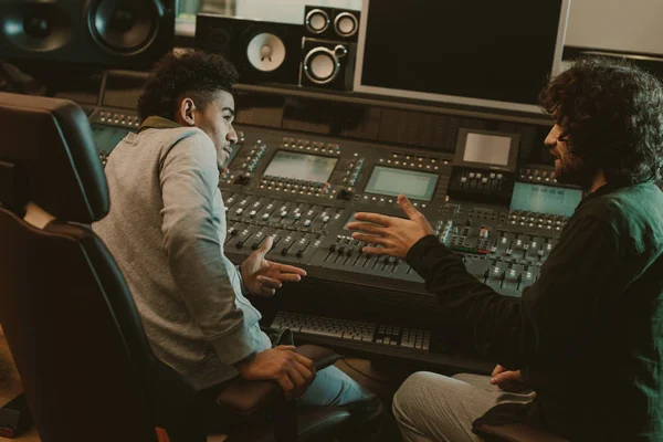 Young musicians talking at recording studio — Stock Photo