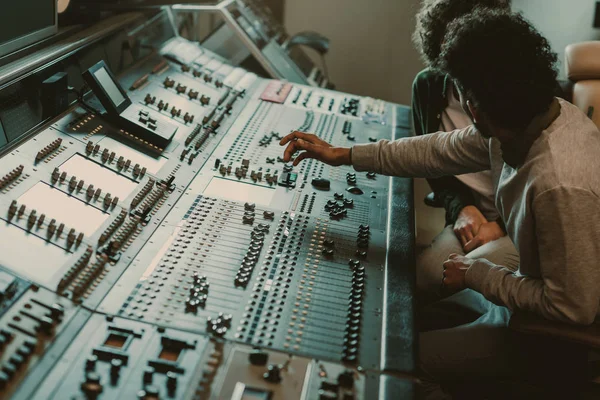 Modern musicians working with graphic equalizer at recording studio — Stock Photo