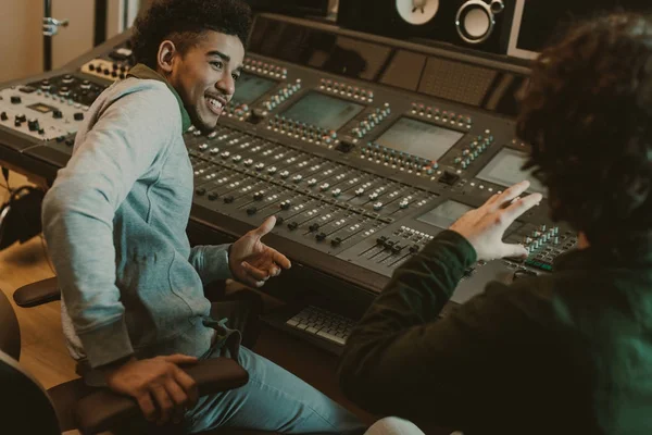 Happy sound producers talking at recording studio — Stock Photo