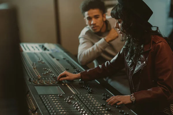 Sound producers working with graphic equalizer at recording studio — Stock Photo