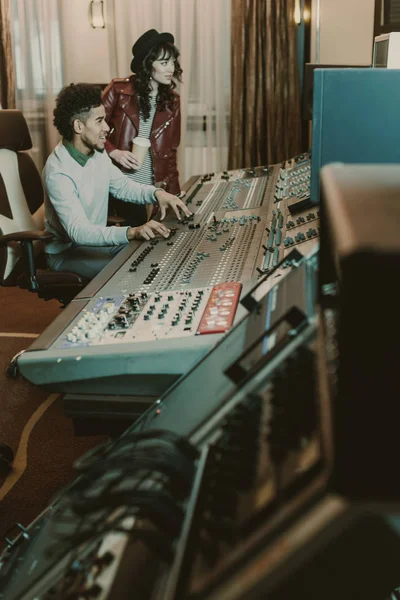 Young successful musicians workign with equipment at recording studio — Stock Photo