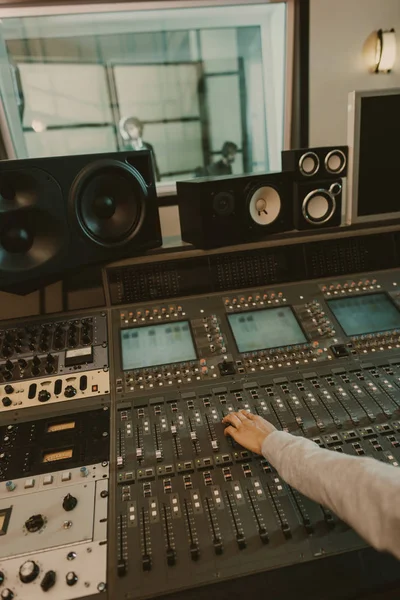 Recortado de productor de sonido trabajando con ecualizador gráfico en el estudio - foto de stock