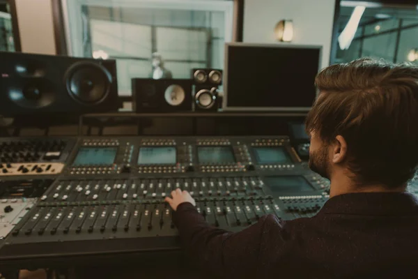 Beau jeune producteur sonore travaillant au studio d'enregistrement — Photo de stock