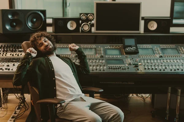 Heureux fatigué producteur sonore étirement en studio — Photo de stock