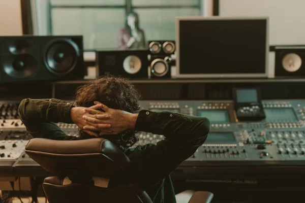 Productor de sonido relajante en sillón en el estudio de grabación - foto de stock