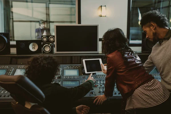 Productores de sonido usando tableta juntos en el estudio de grabación - foto de stock