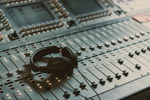 Headphones on graphic equalizer at recording studio — Stock Photo
