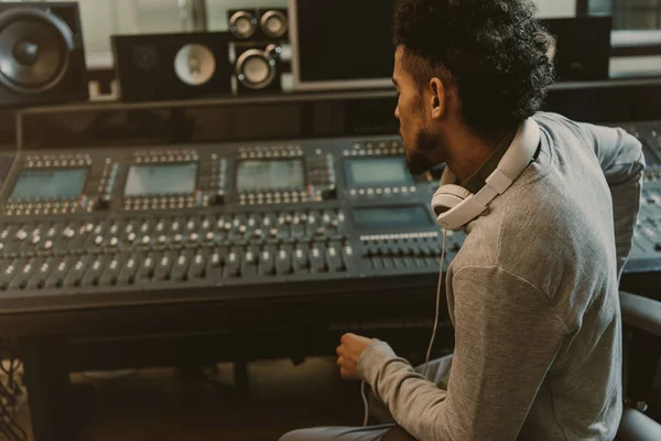 Producteur sonore assis dans le fauteuil et regardant égaliseur graphique — Photo de stock