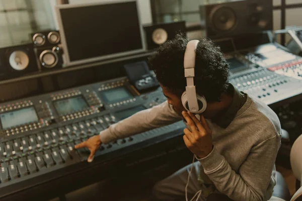 Young african american sound producer working with analog equalizer at studio — Stock Photo