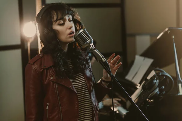 Sensual female singer performing song at recording studio — Stock Photo