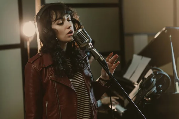 Cantora sensual cantando música no estúdio de gravação — Fotografia de Stock