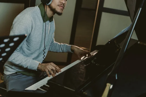 Corte tiro de homem afro-americano tocando piano no estúdio — Fotografia de Stock