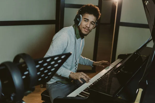 Guapo sonriente pianista realizando canción - foto de stock