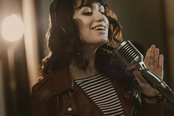 Bela jovem cantora cantando música e sorrindo — Fotografia de Stock