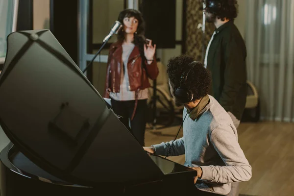 Grupo de músicos cantando en un estudio de grabación - foto de stock