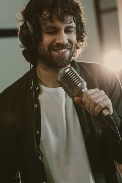 Hübsche junge Sängerin mit Kopfhörer performt Song im Studio — Stockfoto