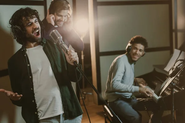 Banda de músicos cantando juntos en el estudio - foto de stock