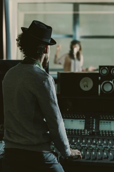 Handsome sound producer in hat recording song at studio — Stock Photo