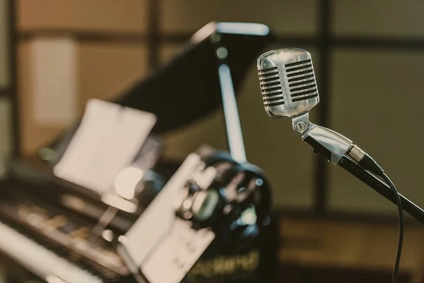 Close-up de microfone vintage na frente de piano desfocado — Fotografia de Stock