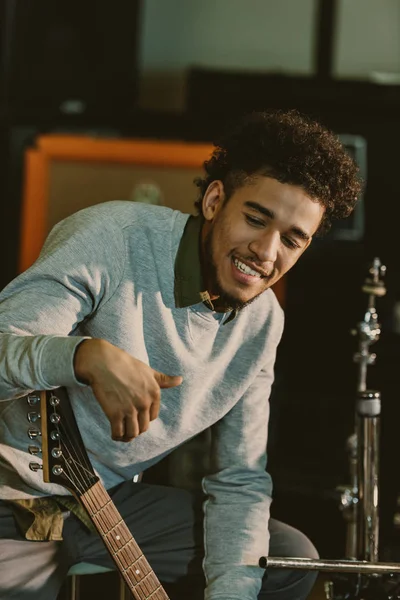 Músico feliz bonito com guitarra elétrica no estúdio — Fotografia de Stock