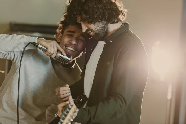 Jovem cantor emocional tocando música perto do guitarrista — Fotografia de Stock