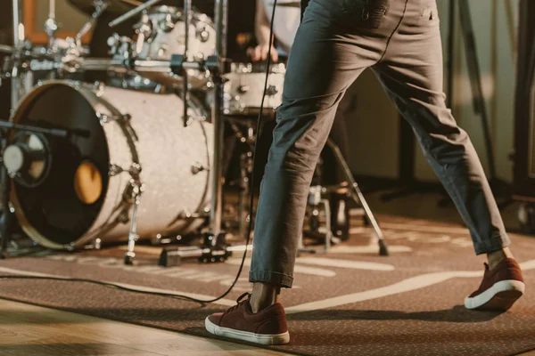 Cropped shot of musician standing in front of drum set on concert — Stock Photo