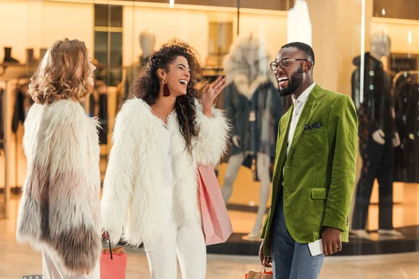 Fröhliche, stylische multiethnische Menschen unterhalten sich beim gemeinsamen Einkaufen in einem Einkaufszentrum — Stockfoto