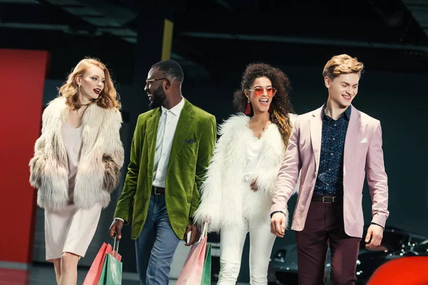 Grupo de jovens compradores multiculturais elegantes andando por auto showroom — Fotografia de Stock