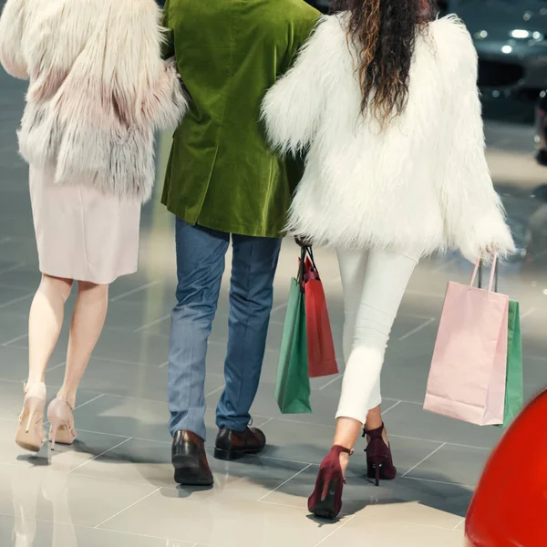 Cropped shot of young shoppers walking by auto showroom — Stock Photo