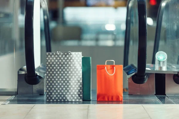 Shopping bags in front of escalator at shopping mall — Stock Photo