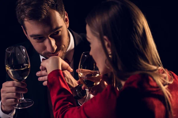 Frau trinkt Wein, während Mann bei romantischem Date im Restaurant ihre Hand küsst — Stockfoto