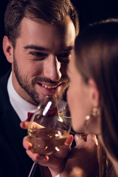 Feliz pareja bebiendo vino blanco en una cita romántica en el restaurante - foto de stock