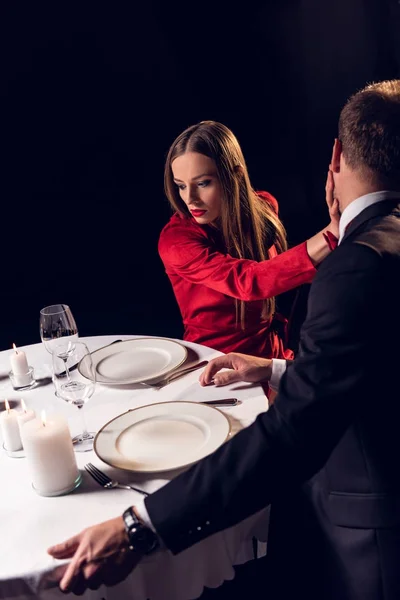 Novia enojada abofeteando a su novio durante una cita romántica en el restaurante - foto de stock