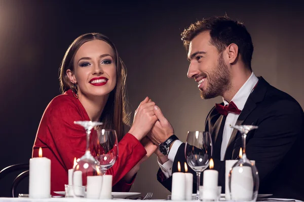 Belo casal feliz de mãos dadas no restaurante — Fotografia de Stock