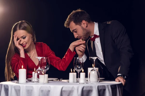 Чоловік цілує руку своєї красивої дівчини на романтичному побаченні в ресторані — стокове фото