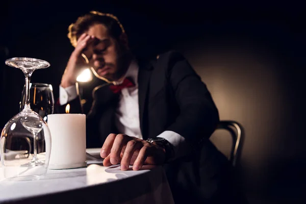 Guapo molesto hombre esperando para romántico fecha en restaurante - foto de stock
