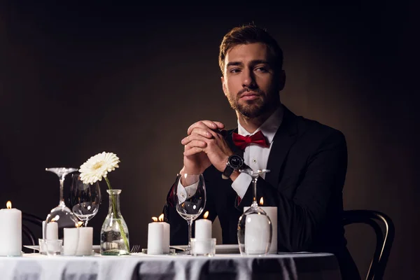 Бородатий чоловік в куртці чекає на романтичне побачення в ресторані — стокове фото