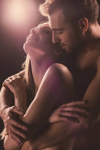 Amantes sensuales abrazos, en marrón con luz de fondo - foto de stock