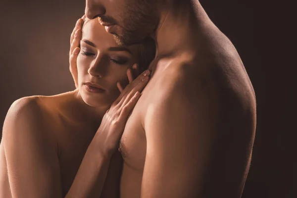 Naked tender couple embracing with closed eyes, on brown — Stock Photo