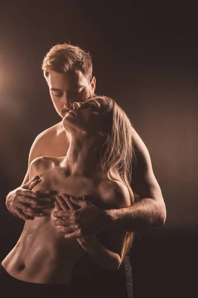 Schöner Freund berühren Brust seiner sexy Freundin, auf braun — Stockfoto