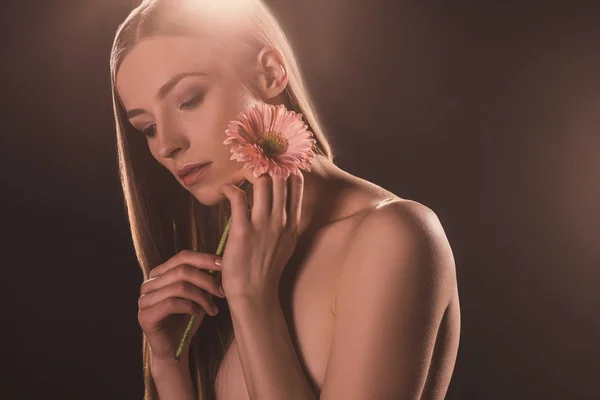 Schöne zarte Mädchen mit Gerbera-Blume, auf braun mit Hintergrundbeleuchtung — Stockfoto