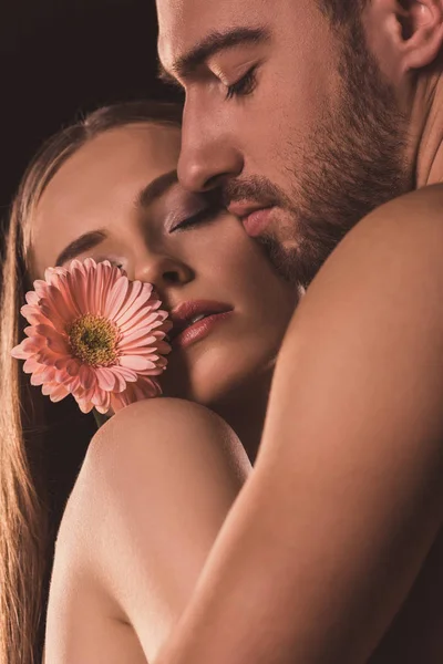 Amantes ternos abraçando e segurando flor de gerbera — Fotografia de Stock
