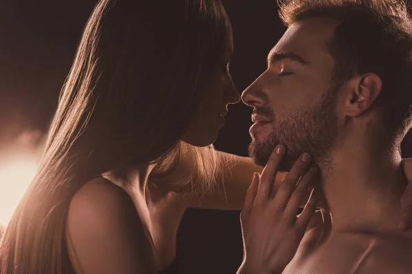 Tender naked couple kissing and looking at each other, on brown with backlit — Stock Photo