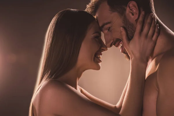 Sensual lovers embracing and laughing, on brown — Stock Photo