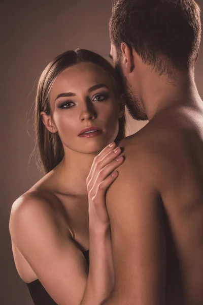 Sensual nude lovers hugging together, on brown — Stock Photo