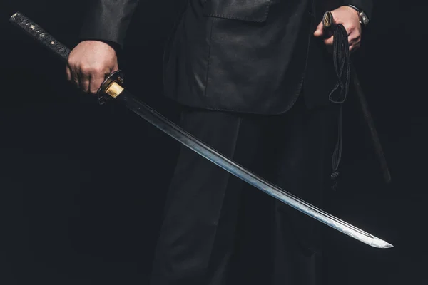 Recortado disparo de hombre con espada katana sobre fondo negro — Stock Photo