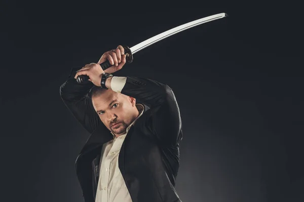 Mature yakuza member in suit with katana sword isolated on black — Stock Photo