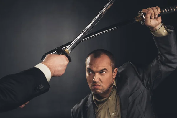 Tiro cortado de samurai moderno lutando com espadas em preto — Fotografia de Stock