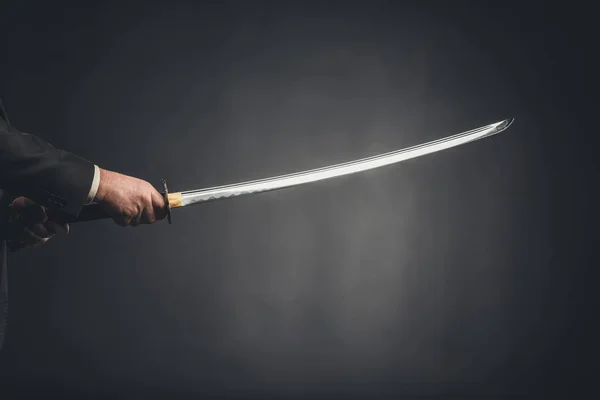 Abgeschnittener Schuss eines Mannes, der Katana auf Schwarz hält — Stockfoto