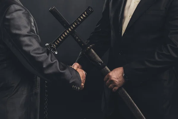 Tiro recortado de reunião de membros de yakuza em ternos com espadas de katana isoladas em preto — Fotografia de Stock